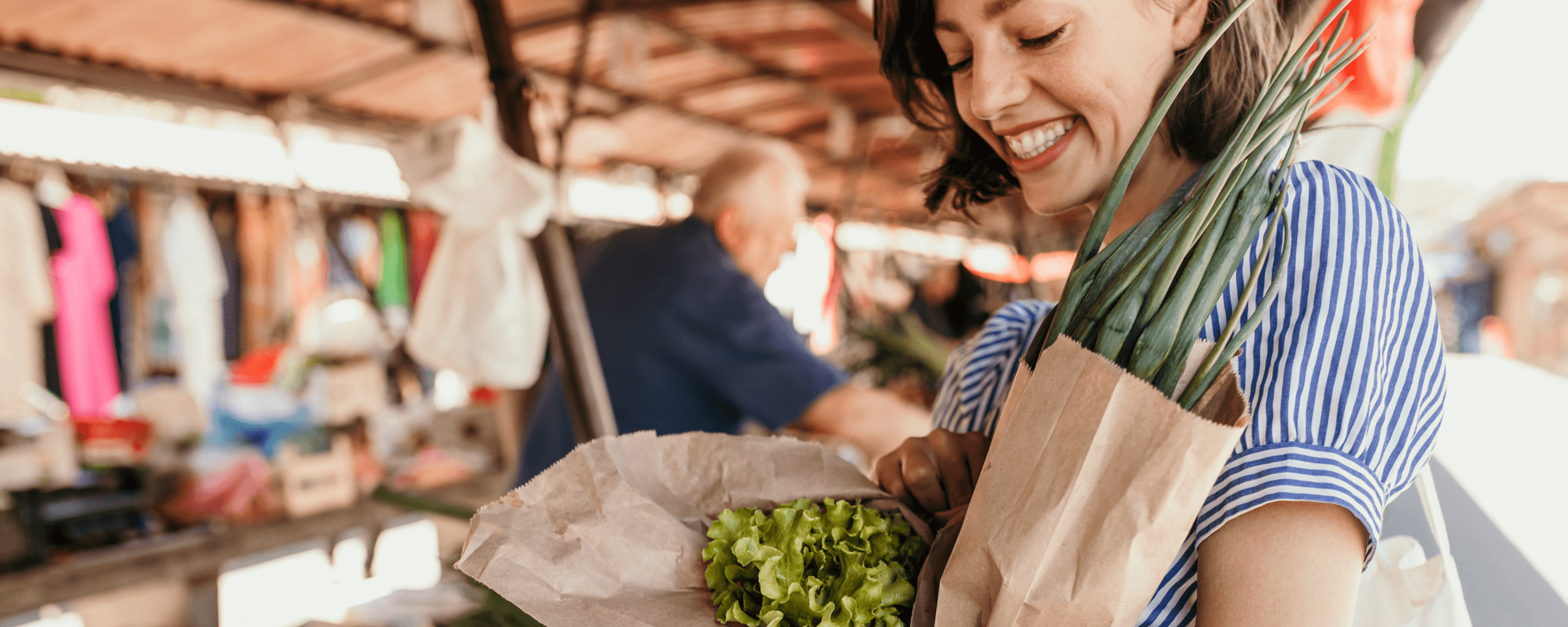 Frau kauft Gemüse auf einem Markt